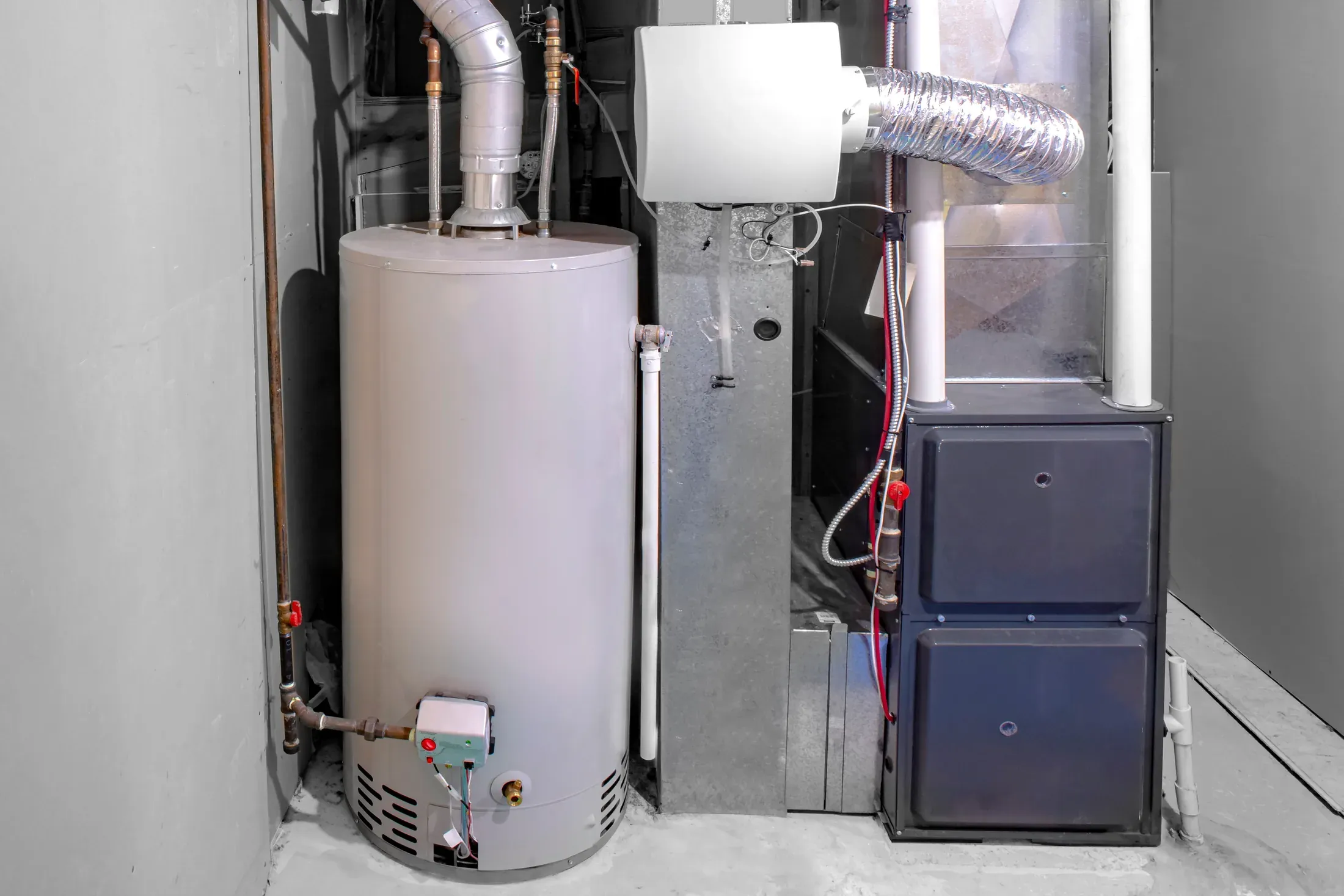 Newly installed high-efficiency residential gas furnace alongside a water heater and humidifier in a home mechanical room